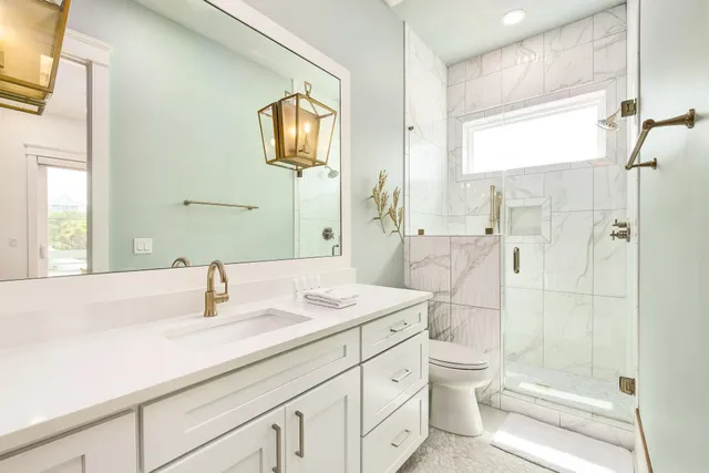 a bathroom with a sink a toilet and shower