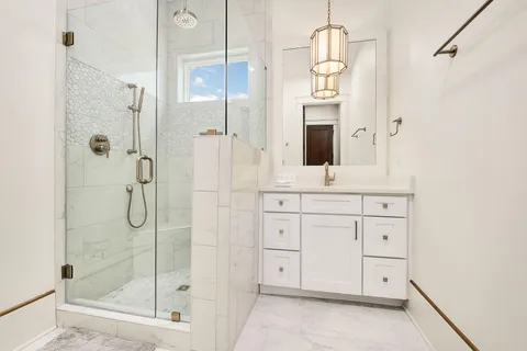 a bathroom with a granite countertop sink a shower and a mirror