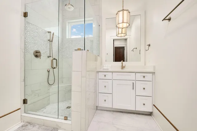 a bathroom with a granite countertop sink a shower and a mirror