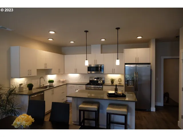a kitchen with a sink refrigerator and microwave