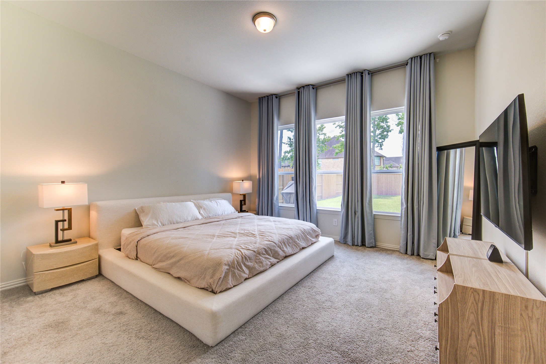 12110 Fletching Stone Lane Houston, TX 77044 - Photo 16 of 50 a bedroom with a bed flat screen tv and a large window