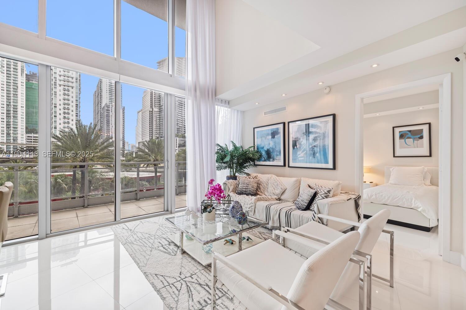 a living room with furniture and a floor to ceiling window