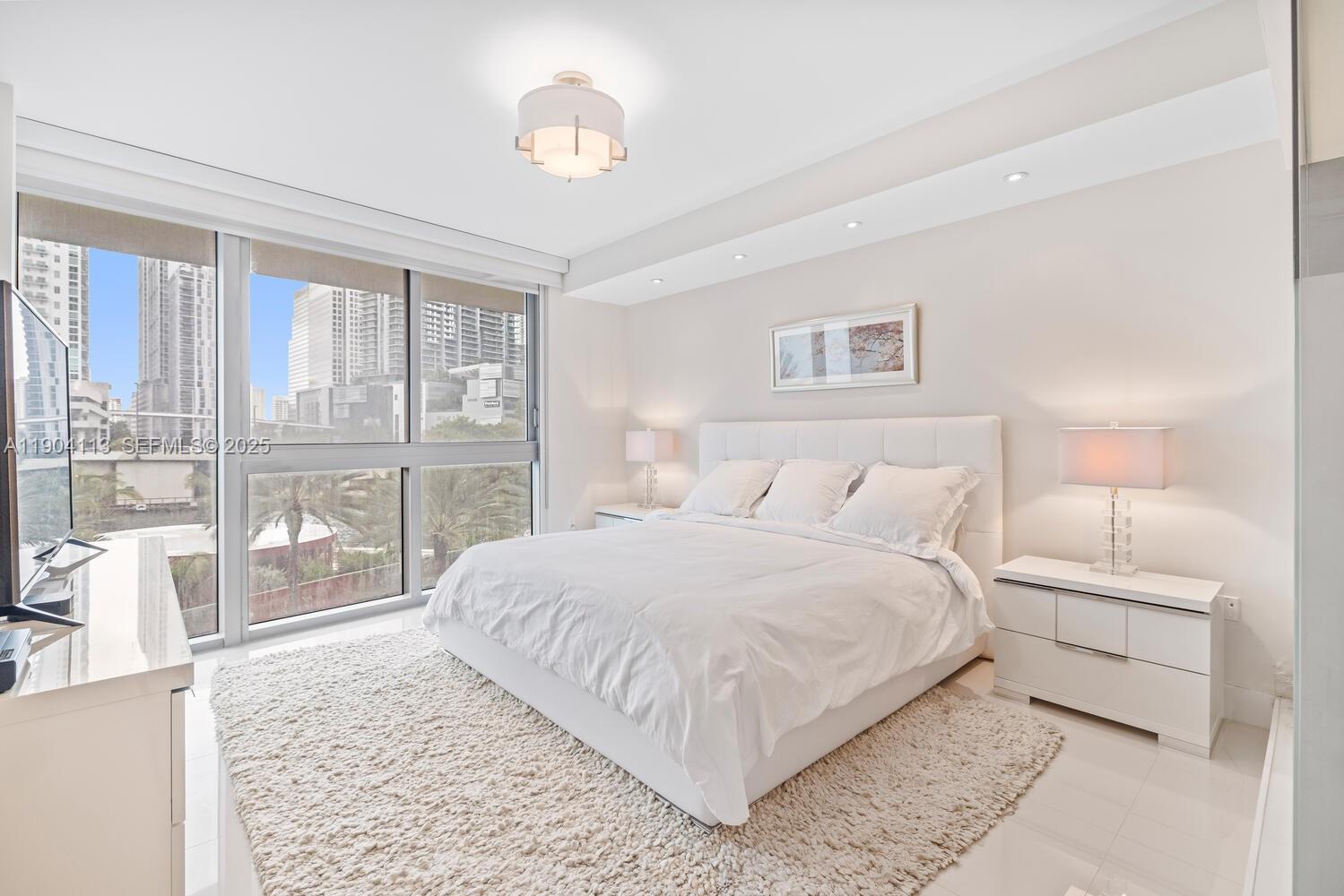 92 Southwest 3rd Street, Unit 310 Miami, FL 33130 - Photo 13 of 40 a bedroom with a large bed and a large window