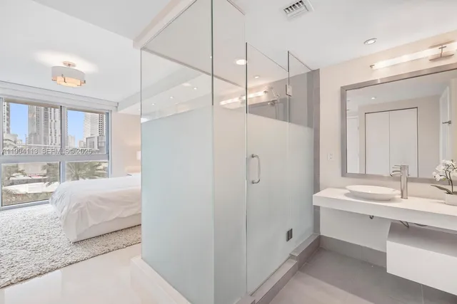 a en suite bathroom with a double sink shower and a mirror