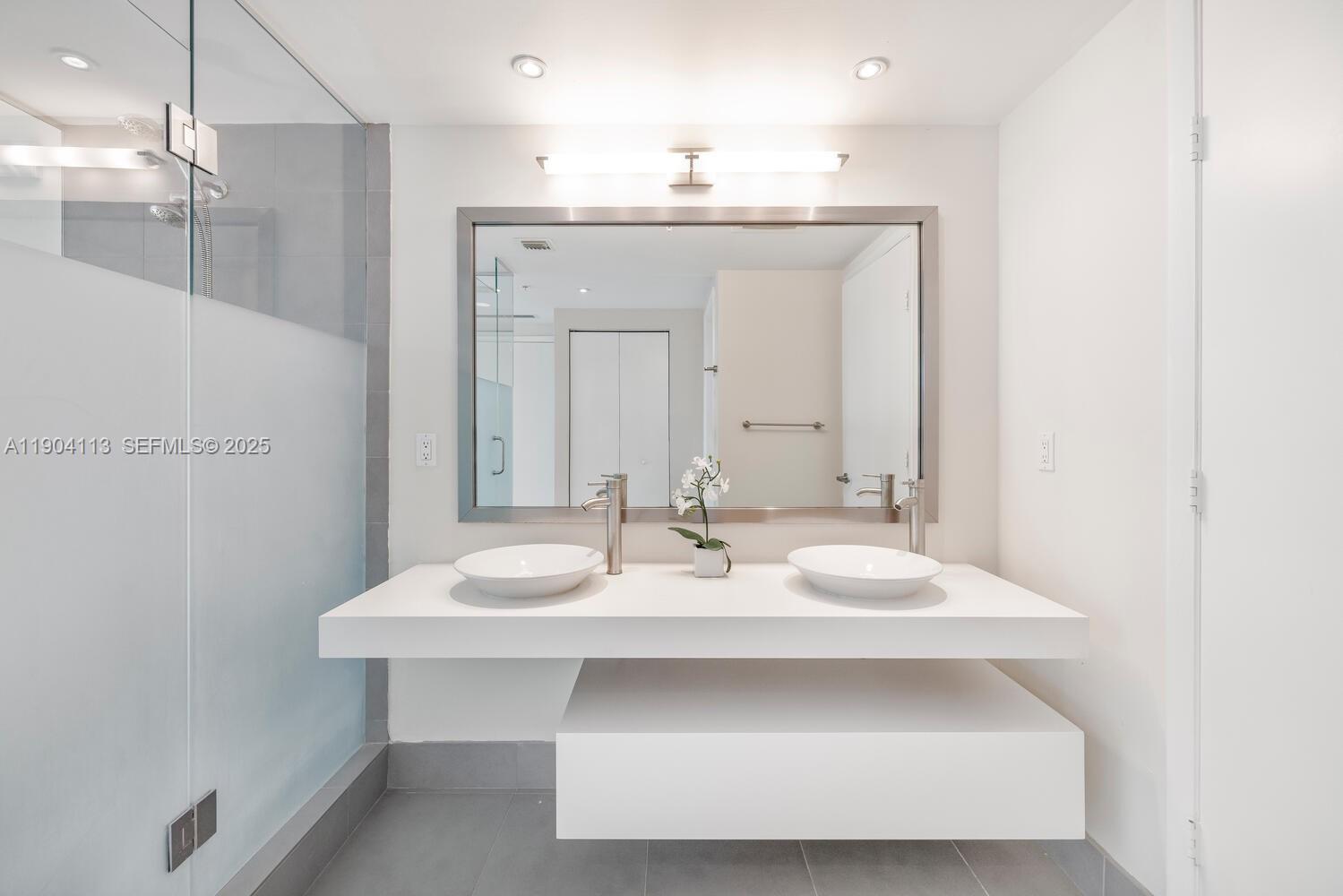 92 Southwest 3rd Street, Unit 310 Miami, FL 33130 - Photo 16 of 40 a bathroom with a sink vanity and a mirror