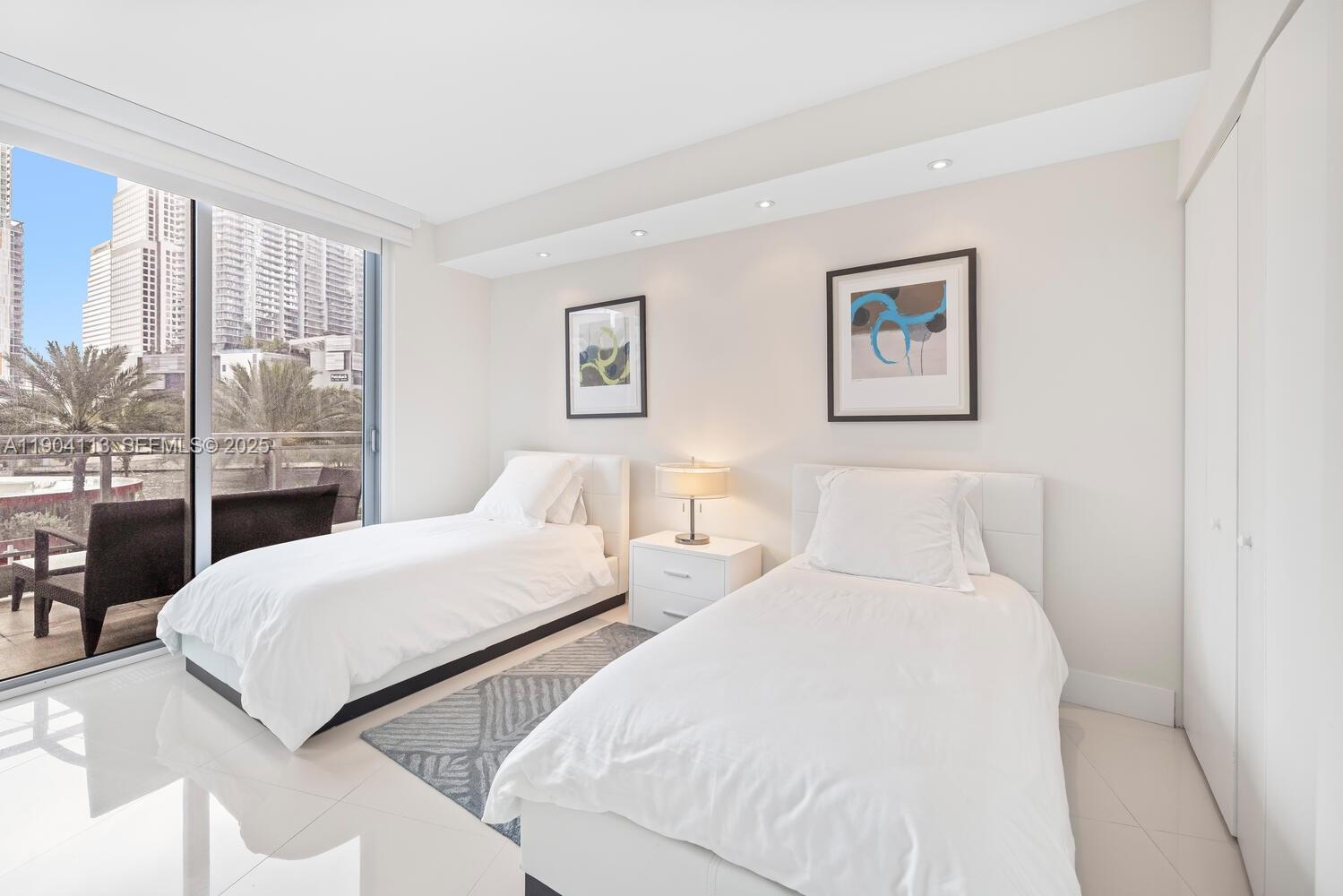 92 Southwest 3rd Street, Unit 310 Miami, FL 33130 - Photo 23 of 40 a bedroom with two beds and a large window