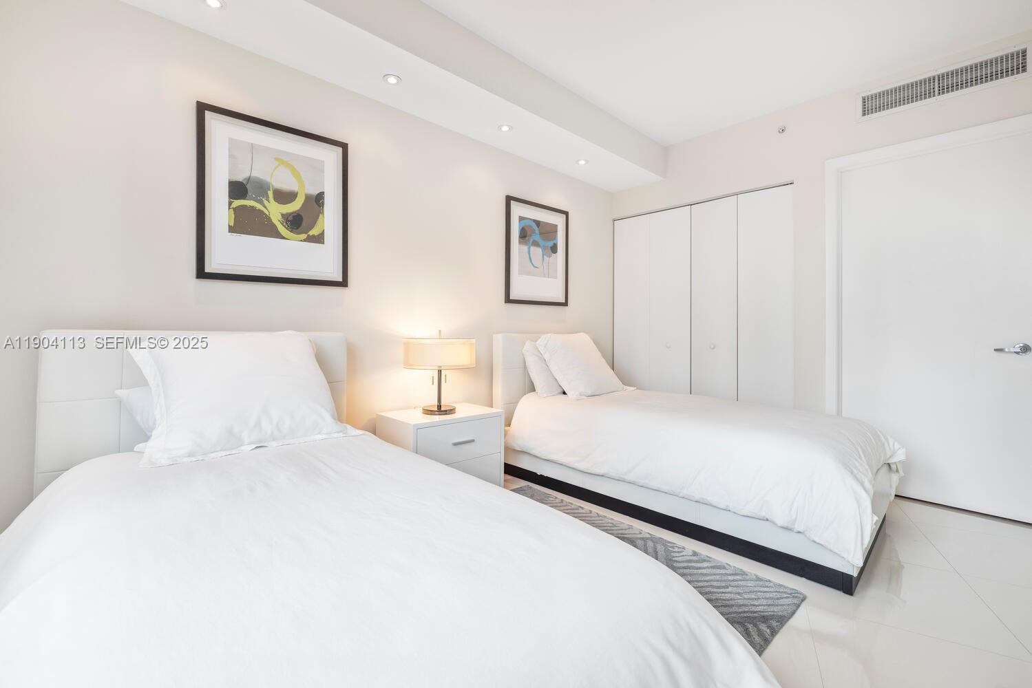 92 Southwest 3rd Street, Unit 310 Miami, FL 33130 - Photo 25 of 40 a bedroom with a bed and a painting on the wall