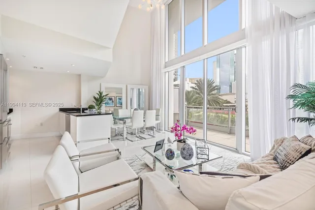 a living room with furniture and floor to ceiling windows
