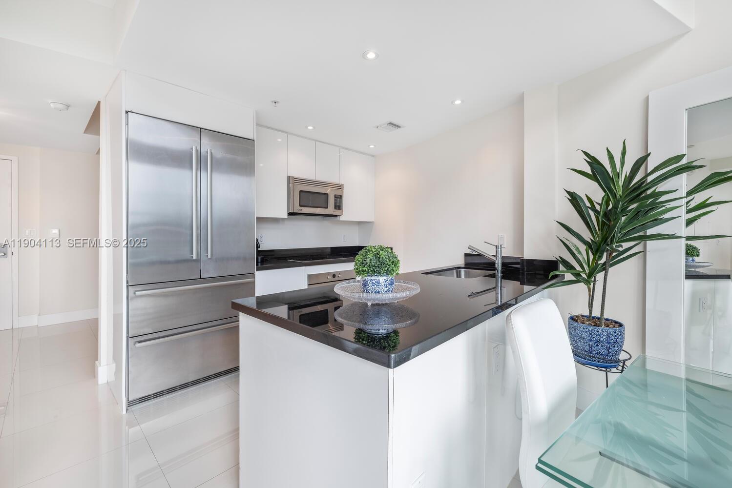 92 Southwest 3rd Street, Unit 310 Miami, FL 33130 - Photo 7 of 40 a kitchen with kitchen island a counter top space a sink and stainless steel appliances