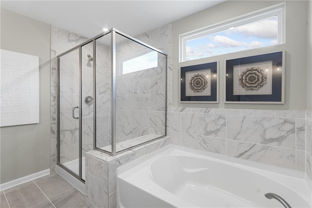 4387 Azalea Ridge Way Hoschton, GA 30548 - Photo 17 of 30 a bathroom with a shower and a bathtub