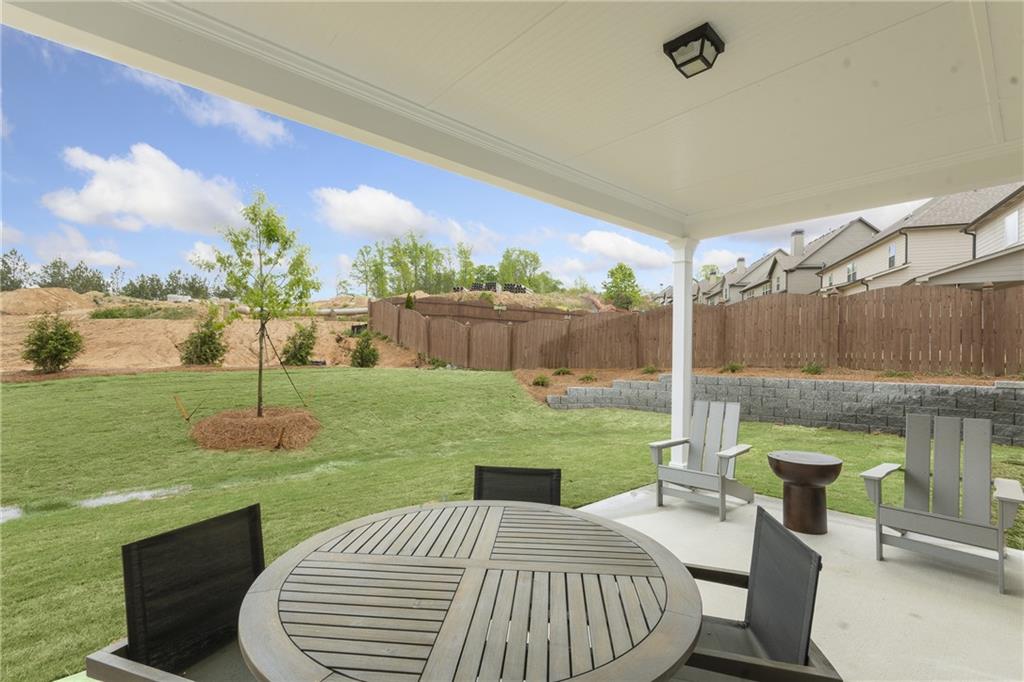 4387 Azalea Ridge Way Hoschton, GA 30548 - Photo 22 of 30 a view of a patio with a table chairs and a backyard
