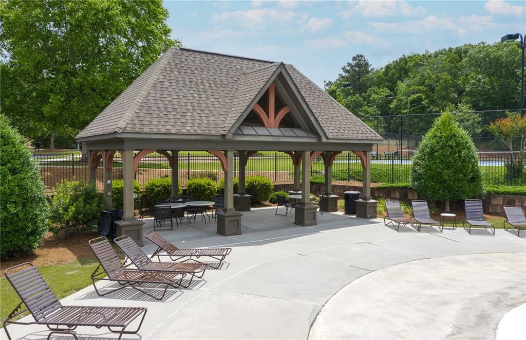 4387 Azalea Ridge Way Hoschton, GA 30548 - Photo 28 of 30 a patio with a table and chairs under an umbrella