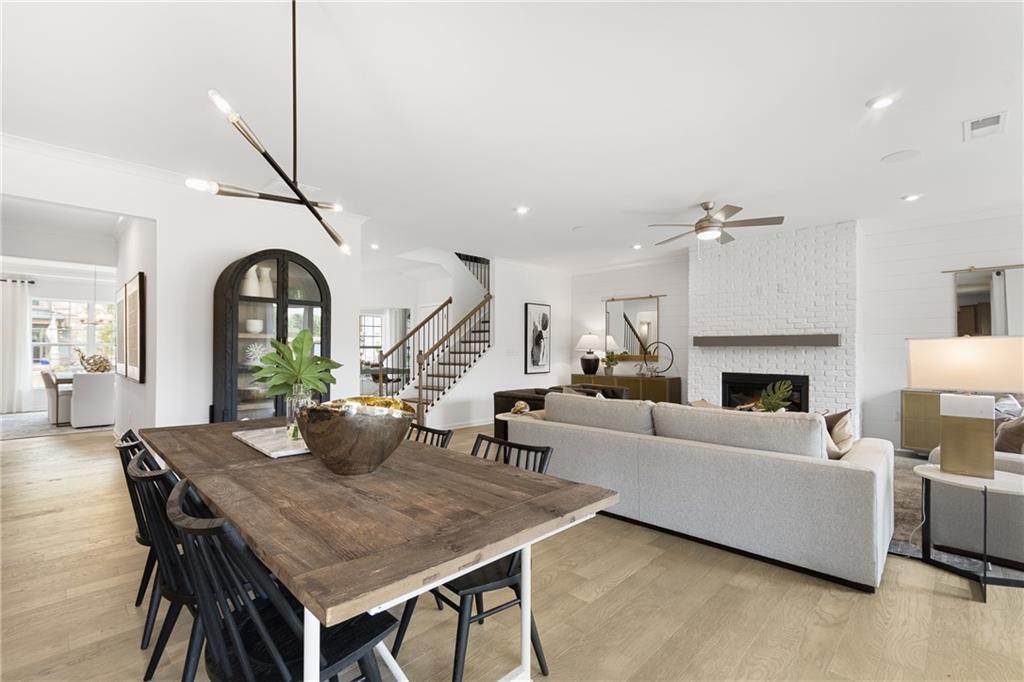 4387 Azalea Ridge Way Hoschton, GA 30548 - Photo 8 of 30 a living room with furniture a fireplace and a chandelier