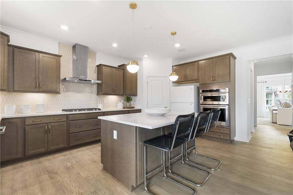 4387 Azalea Ridge Way Hoschton, GA 30548 - Photo 9 of 30 a kitchen with stainless steel appliances kitchen island granite countertop a sink and cabinets