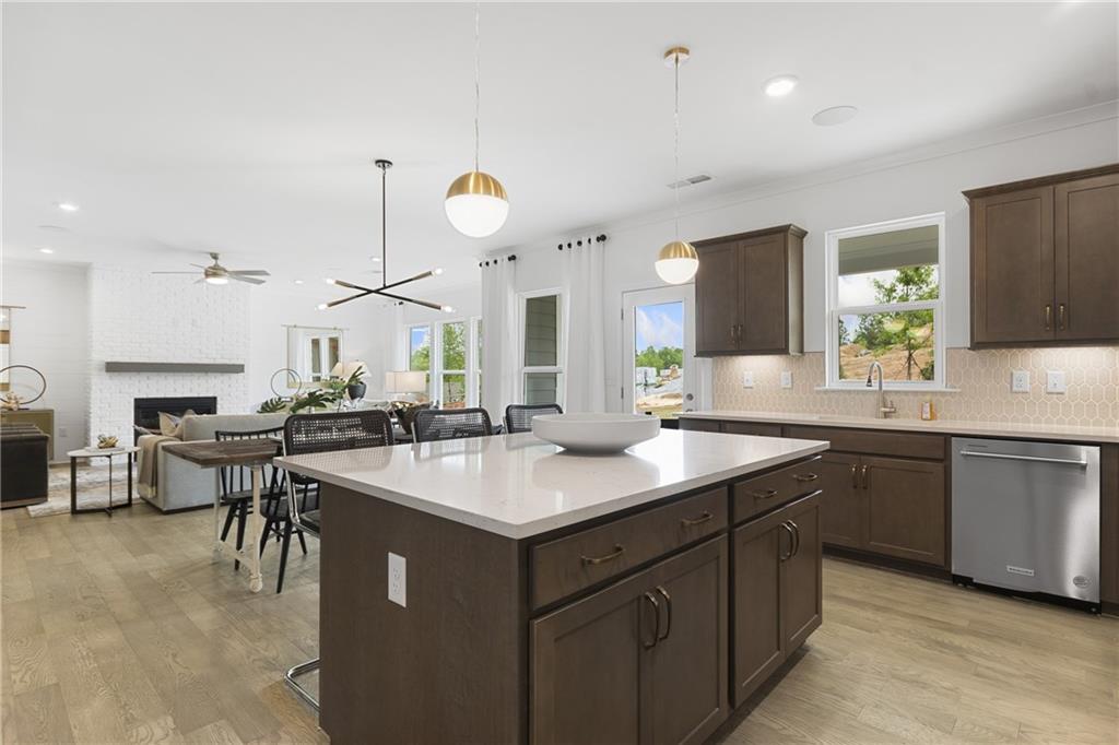 4387 Azalea Ridge Way Hoschton, GA 30548 - Photo 10 of 30 a kitchen with a sink a counter and chairs