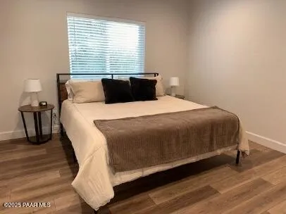 a bedroom with a bed and wooden floor