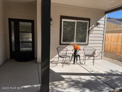 a patio with table and chairs and potted plants