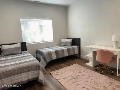 a bedroom with two beds and a chair