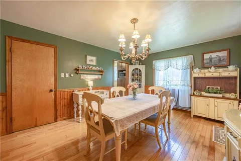 a view of a dining room with furniture a chandelier and wooden floor