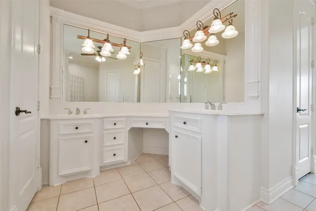 an empty room with a chandelier fan and windows