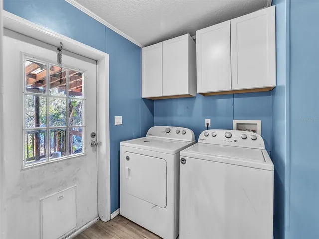 an empty room with wooden floor closet and windows