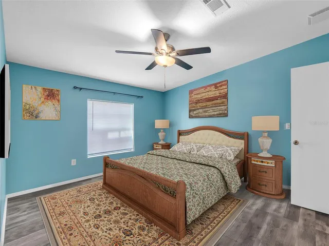 a bedroom with a bed a mirror and a large window