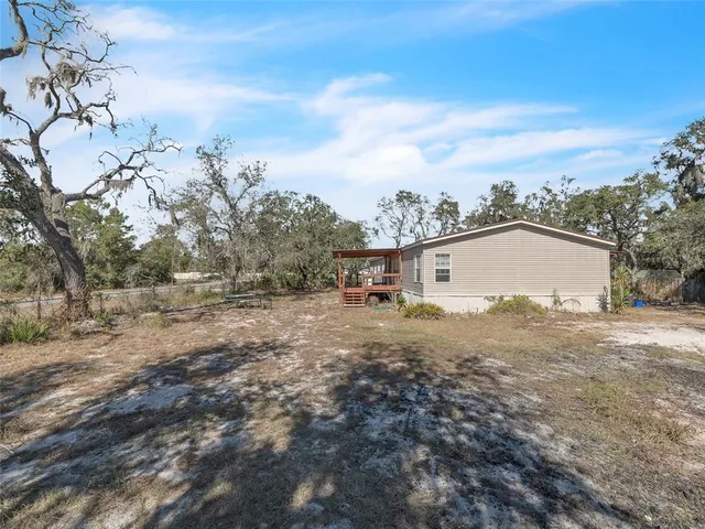 a view of a house with backyard and trees