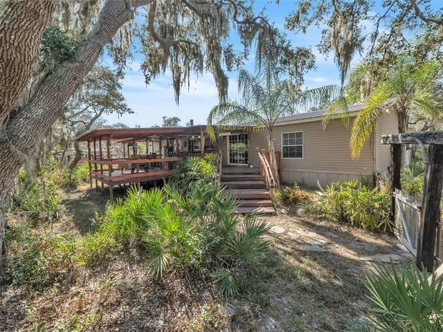 a view of a house with a yard and potted plants