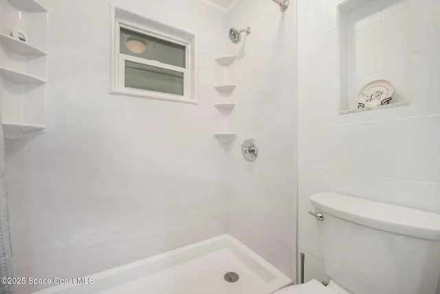 a bathroom with a shower and a toilet