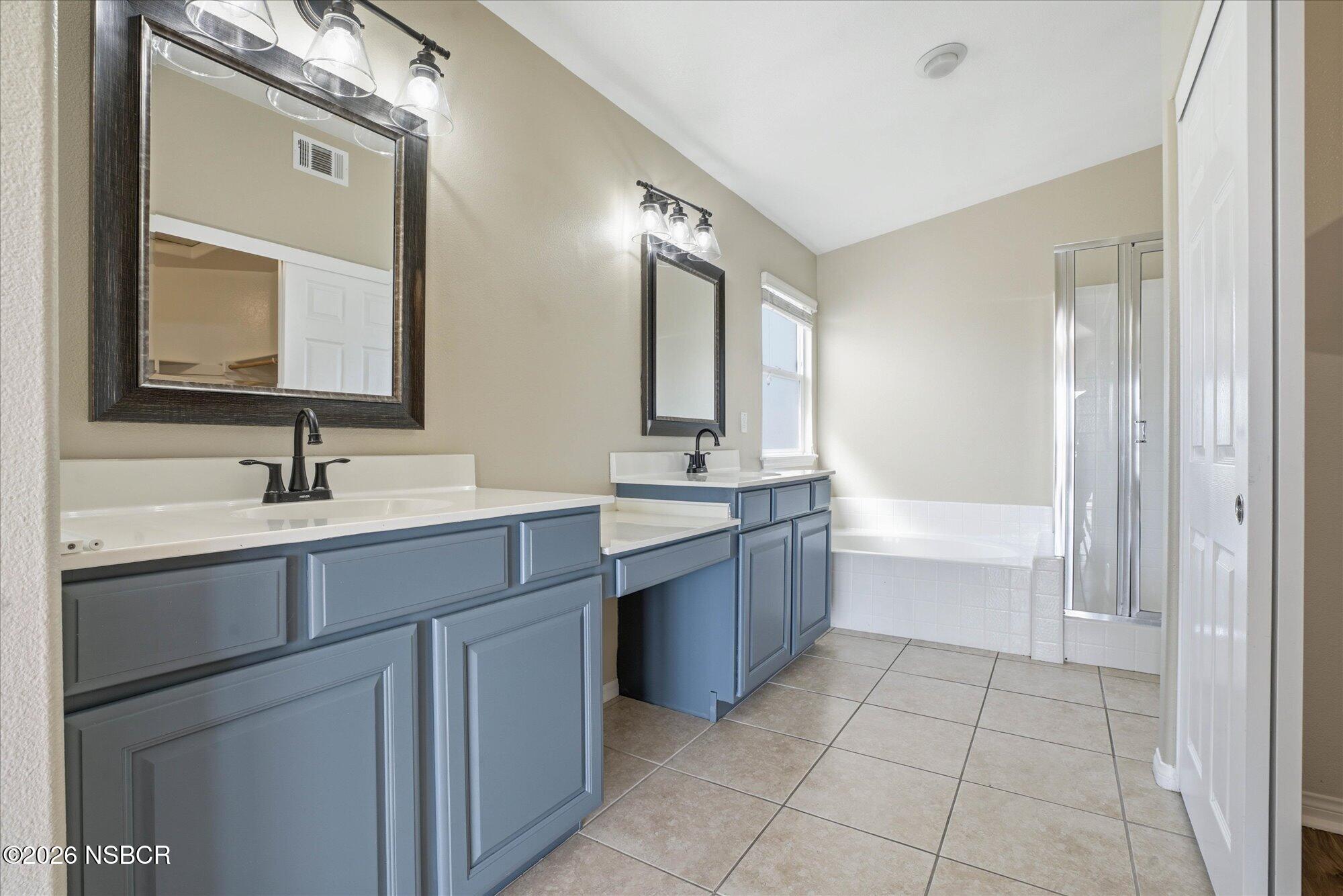 280 Rinconcito Lompoc, CA 93436 - Photo 22 of 39 a bathroom with a bathtub shower sink vanity and mirror