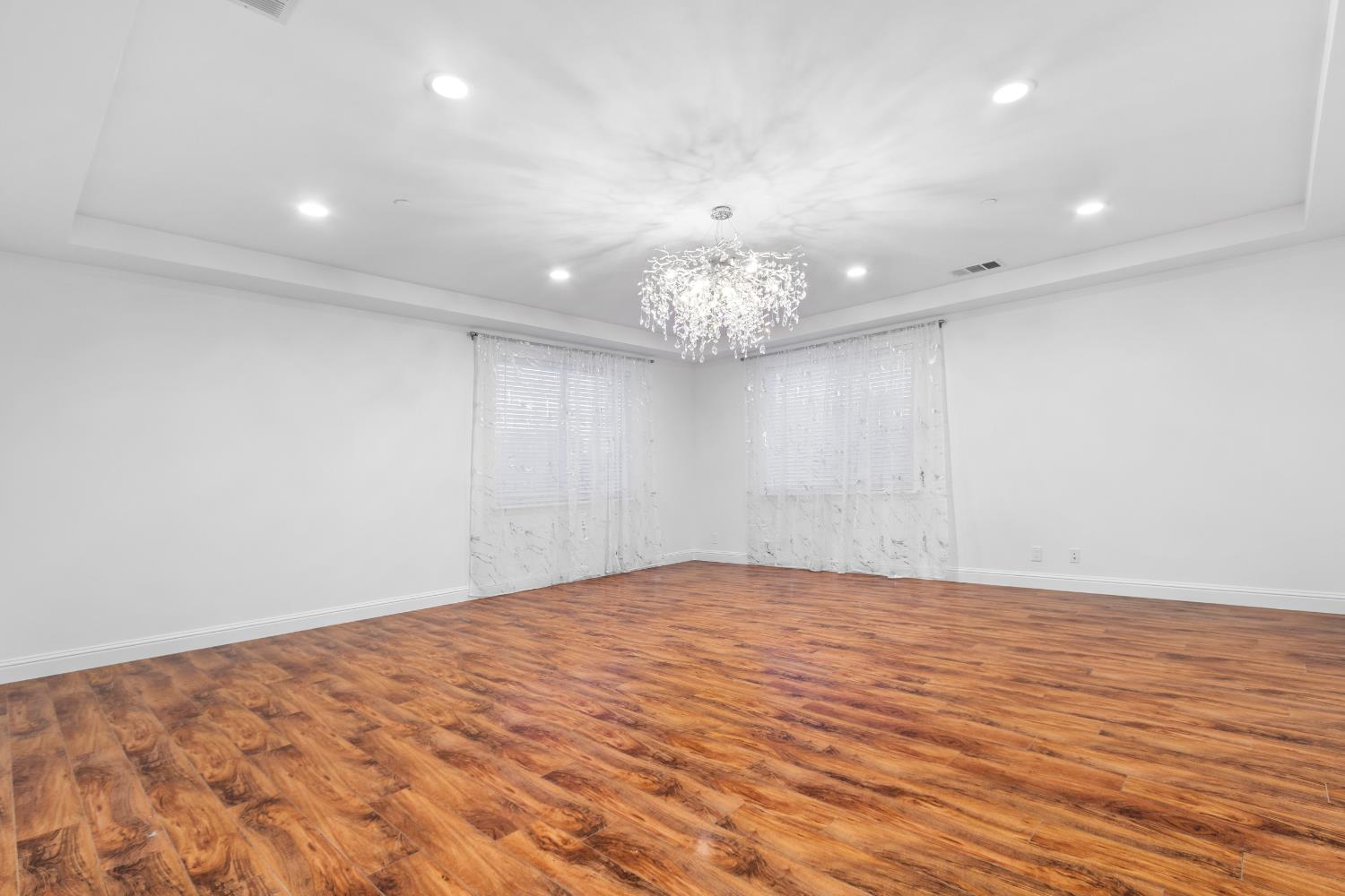 6404 Sylvan Road Citrus Heights, CA 95610 - Photo 5 of 20 a view of an empty room with wooden floor and a chandelier