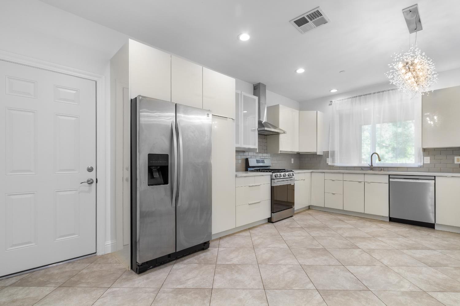 6404 Sylvan Road Citrus Heights, CA 95610 - Photo 6 of 20 a large kitchen with a refrigerator a stove top oven and kitchen island