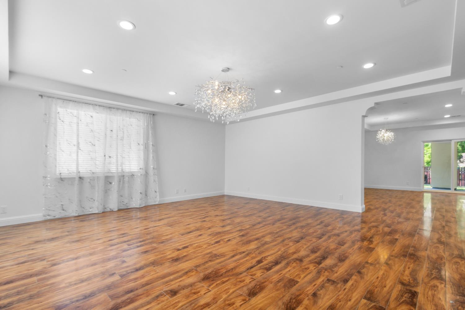 6404 Sylvan Road Citrus Heights, CA 95610 - Photo 10 of 20 a view of an empty room with wooden floor and a chandelier