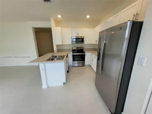 a kitchen with stainless steel appliances a refrigerator and a stove top oven