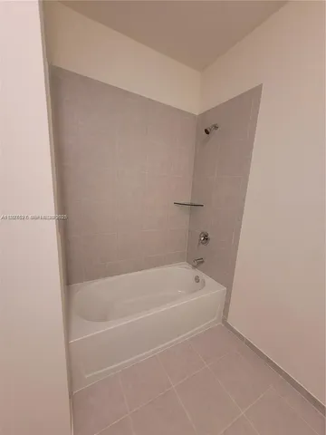 a white bath tub sitting next to a shower