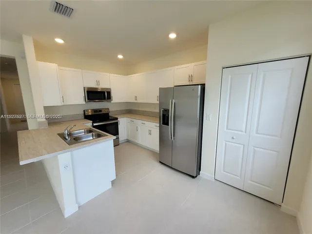 a kitchen with stainless steel appliances a refrigerator stove microwave and sink