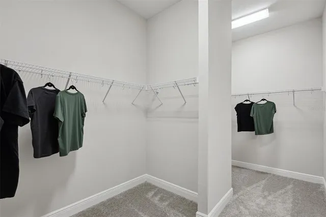 a view of walk in closet with clothes and shoes