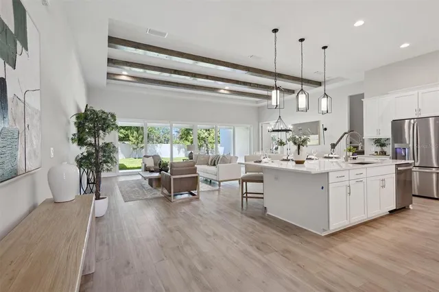 a kitchen with stainless steel appliances kitchen island granite countertop a stove a sink and a living room view