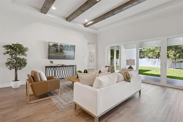 a living room with furniture and a large window with garden view