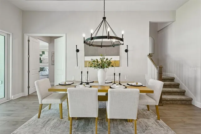 a dining room with furniture a chandelier and wooden floor
