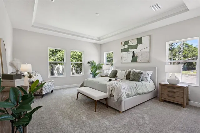 a spacious bedroom with a bed couch and a potted plant