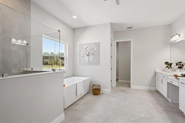 a spacious bathroom with a tub sink and mirror