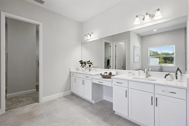 a view of a sink mirror and cabinets