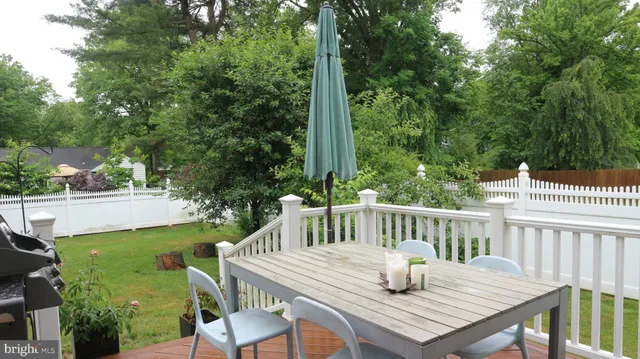 a balcony with wooden floor table and chairs