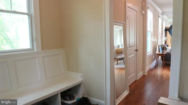 a hallway with wooden floor windows and livingroom