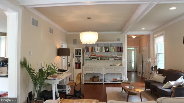 a living room with furniture a chandelier and a floor to ceiling window