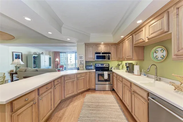 a large kitchen with stainless steel appliances granite countertop a lot of counter space and a sink