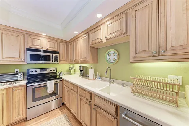 a kitchen with stainless steel appliances granite countertop a sink and dishwasher a stove top oven with white cabinets