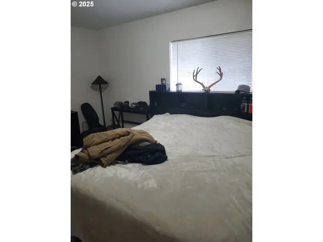 a bedroom with a bed and a painting on the wall