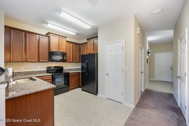 a kitchen with stainless steel appliances granite countertop a refrigerator stove top oven a sink and dishwasher